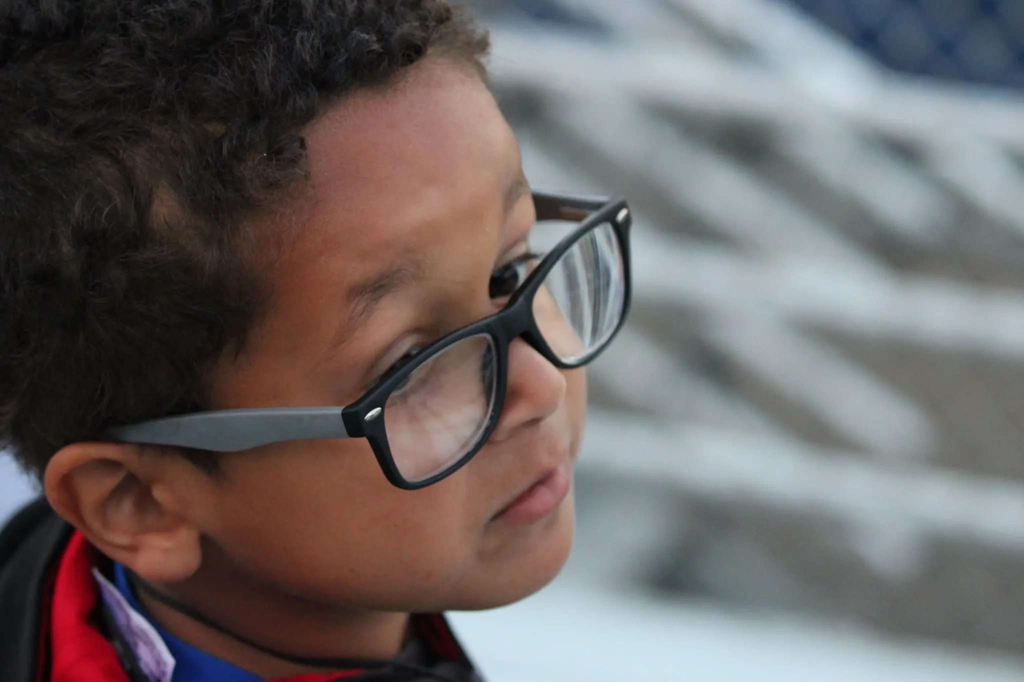 Close candid portrait of a child wearing black glasses