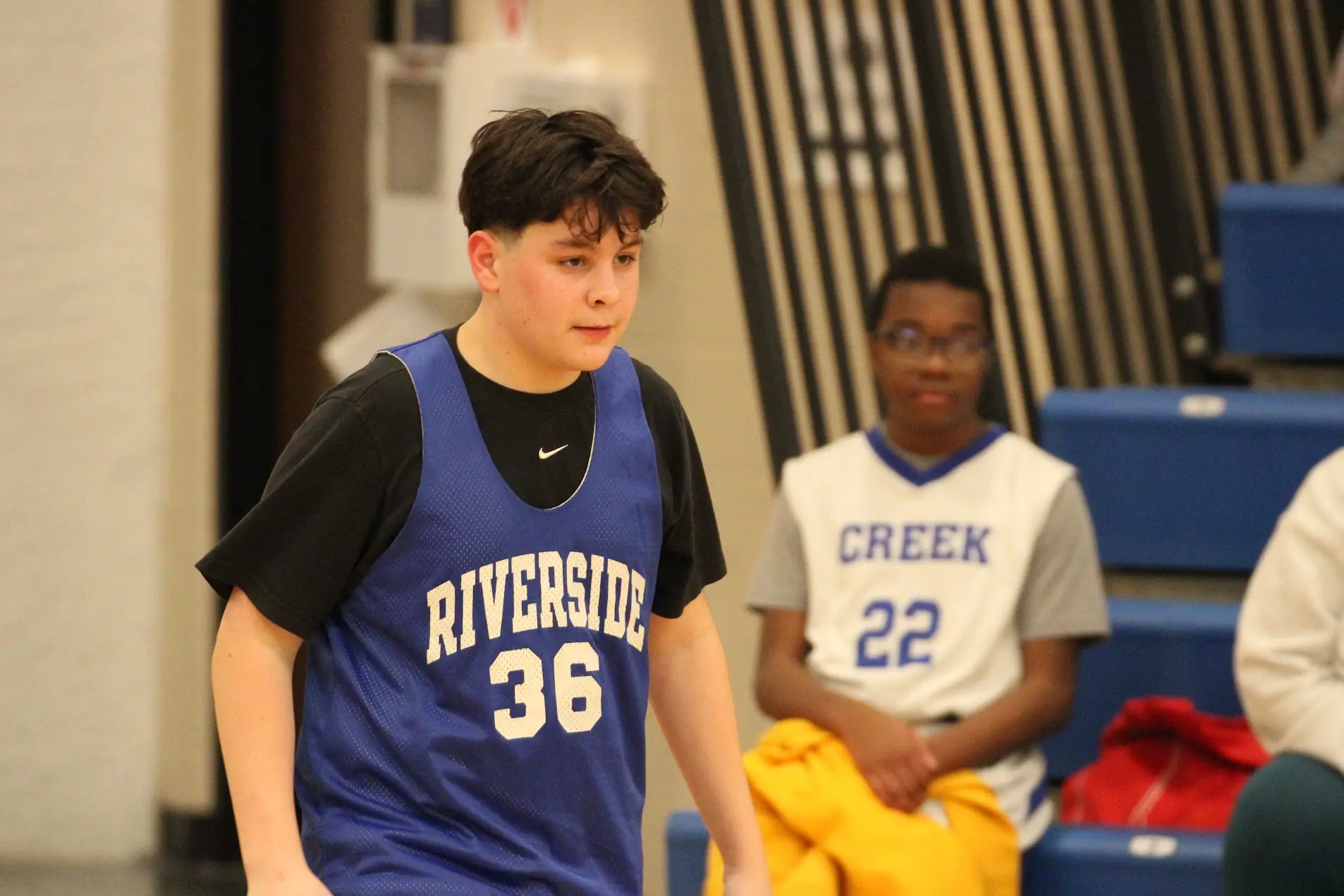 Young basketball player focused between plays in a gym